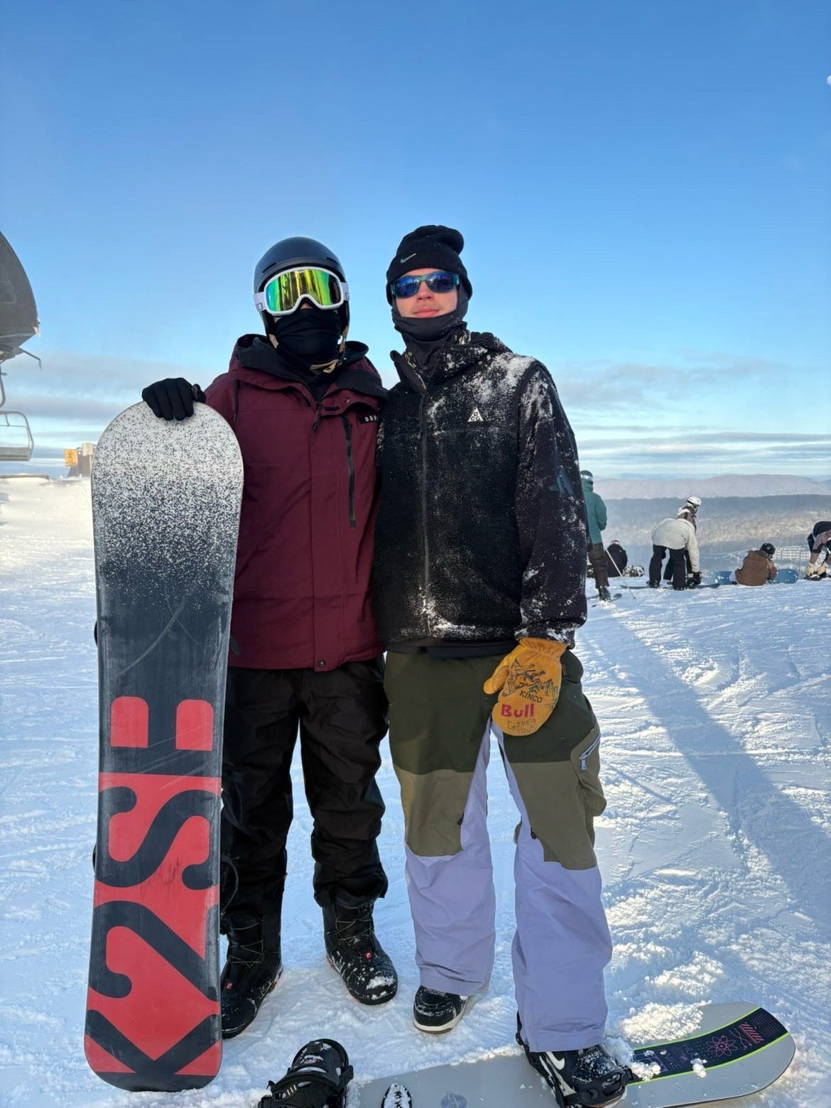 Two brothers snowboarding together in the mountains
